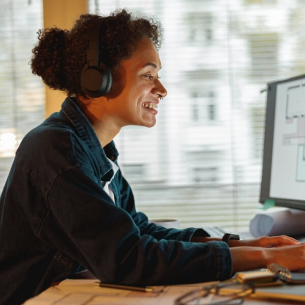 Mitarbeiterin mit Headset an einem modernen digitalen Arbeitsplatz