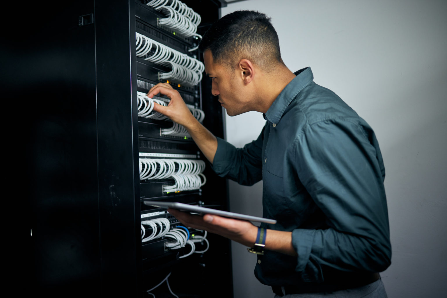 Techniker prüft die Verkabelung in einem Netzwerkschrank