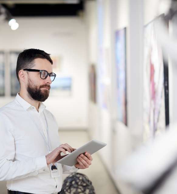Mann mit Tablet in einer Galerie