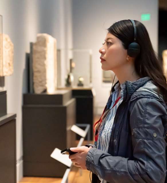 Besucherin mit Audioguide im Museum