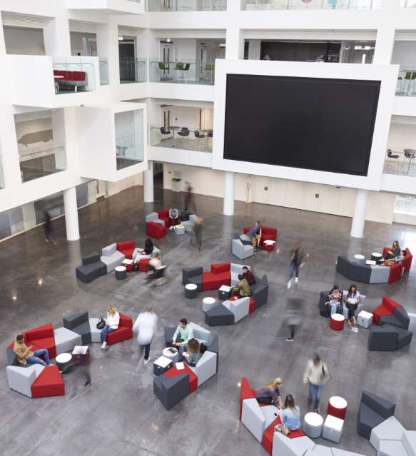 Atrium mit großer Videowand und Sitzgruppen
